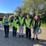 5 teenage boys in high viz jackets with litter pickers ready to go on a litter pick