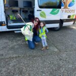 a mother and her young child in high viz jackets with litter pickers ready to go on a litter pick